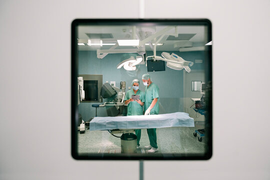 Surgeons using digital tablet during surgery in operating room