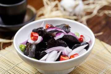 Black fungus with onion sauce on a white porcelain plate