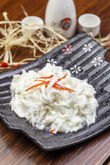 Sakura shrimp with egg paste on a black ceramic plate