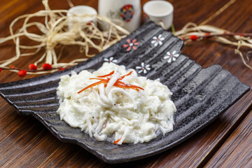 Sakura shrimp with egg paste on a black ceramic plate