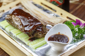 Roasted beef ribs with sauce on wooden tray