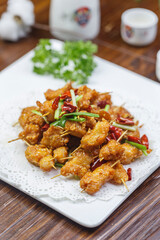 Crispy toothpick meat in a square white porcelain plate