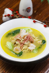 White round porcelain plate with ham, shrimp and dried shredded pork in thick soup