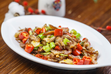 Hunan-style stir-fried pork belly in a leaf-shaped porcelain plate