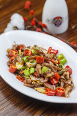 Hunan-style stir-fried pork belly in a leaf-shaped porcelain plate