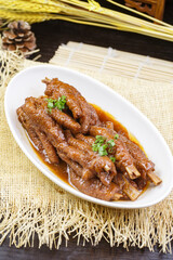 Teriyaki chicken feet on a white porcelain plate