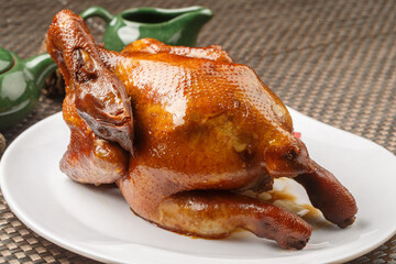 Hong Kong-style crispy chicken in a white round porcelain plate placed on a placemat