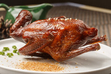 Hong Kong-style crispy pigeon in a round white porcelain plate placed on a placemat
