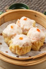 Pineapple buns in a round white porcelain plate are placed on a placemat