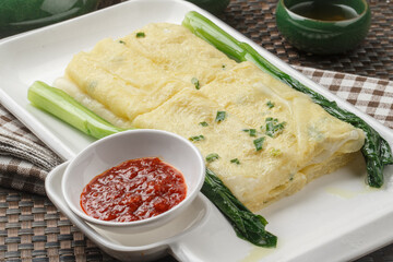 Hong Kong-style egg pancakes in a rectangular white porcelain plate are placed on a placemat