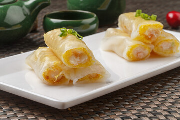 Hong Kong-style egg pancakes in a rectangular white porcelain plate are placed on a placemat