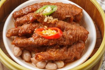 Steamed chicken feet in a basket are placed on a tablecloth