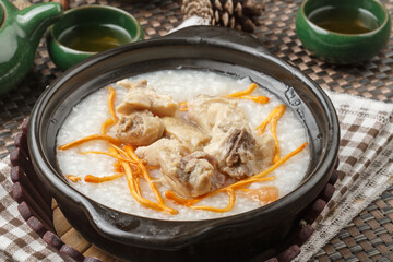 Cordyceps flower pork ribs porridge in a black casserole placed on the tablecloth