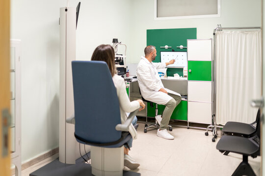 Ophthalmologist showing eye exam results to patient in clinic