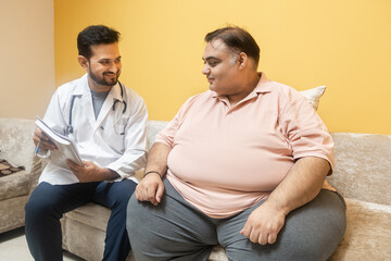 Male indian doctor consulting with overweight patient. Healthcare worker advice obese man to lose...