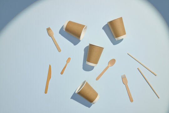 Eco-Friendly Disposable Utensils and Cups on Soft Colored Background
