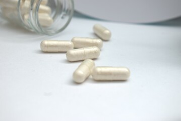 High-quality image of pharmaceutical pills, capsules, and blister packs arranged on clean...