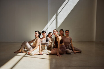 Diverse group of dancers posing in a sunlit studio