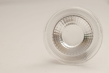 Minimalist photo of a circular LED spotlight reflector or optical lens on a clean white background. Ideal for use in lighting product catalogs, technology articles, electronics presentations, or indus