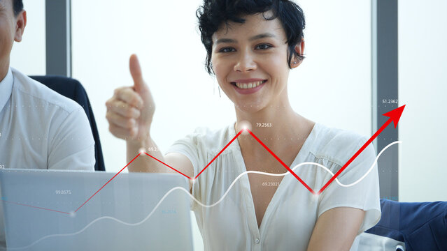 Confident businesswoman smiling and giving thumbs up in front of laptop, red upward financial chart overlay symbolizing success, business growth, investment profits and positive company performance.