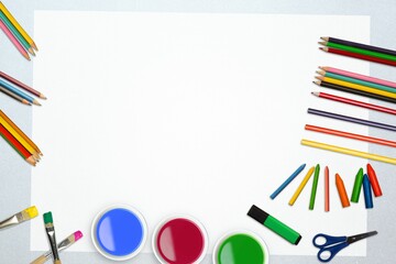 Obraz premium Flat design blank white sheet is lying on silver desk, framed by colored art supplies, scissors