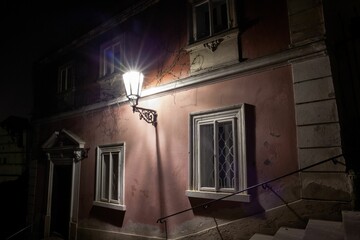 Flat design showing nighttime alley lighting pink wall lamp casting starburst glow on vine remnants