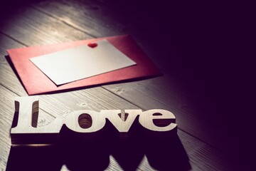 Love text with envelope on wooden table