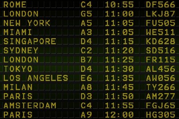 Black airport departures board with yellow text