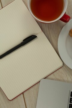 Fototapeta Laptop, lemon tea, croissant and diary on table