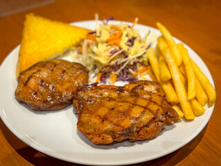 Pork steak with potato fried and salad on the table