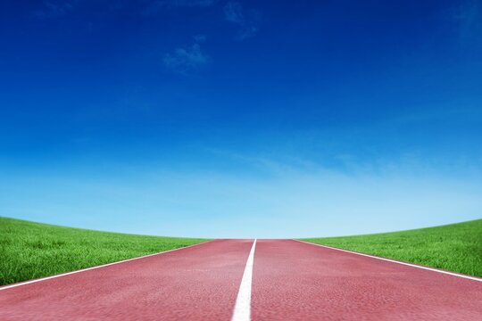 Fototapeta Red track with white center line is being shown in flat design through grassy hills