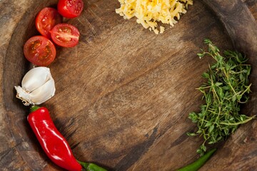 Halved tomatoes with spices in wooden container