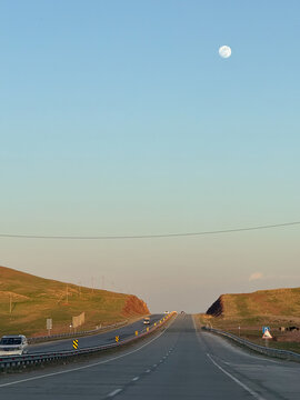 Open highway at dusk with rising moon