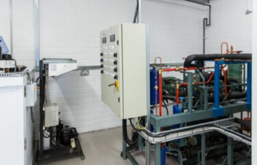 Flat design showing beige control panel cabinet on white brick wall, featuring pipes, cable trays