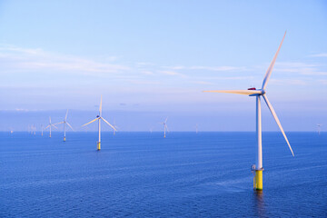 Wind turbines generate clean, renewable electricity against a blue sky, symbolizing sustainable energy for the environment
