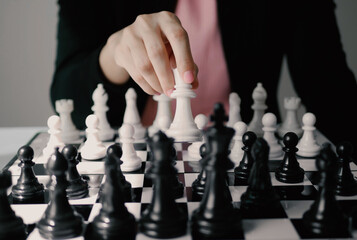 Businesswoman play a game of chess to be a concept of business competition and problem solving For...