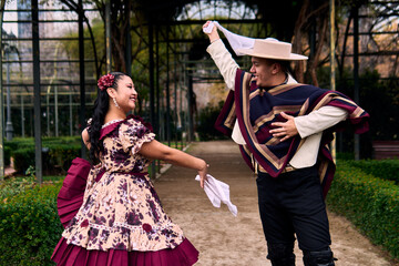 A pair of young Chilean Latin dancers dancing cuecas, the Chilean national dance, in a very...