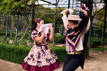 A pair of young Chilean Latin dancers dancing cuecas, the Chilean national dance, in a very...
