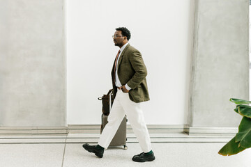 Business Traveler Walking With Suitcase in Modern Airport Terminal