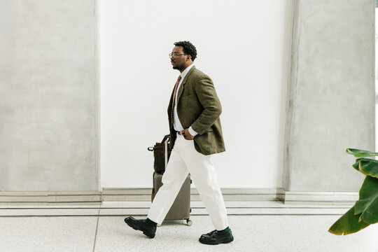 Business Traveler Walking With Suitcase in Modern Airport Terminal