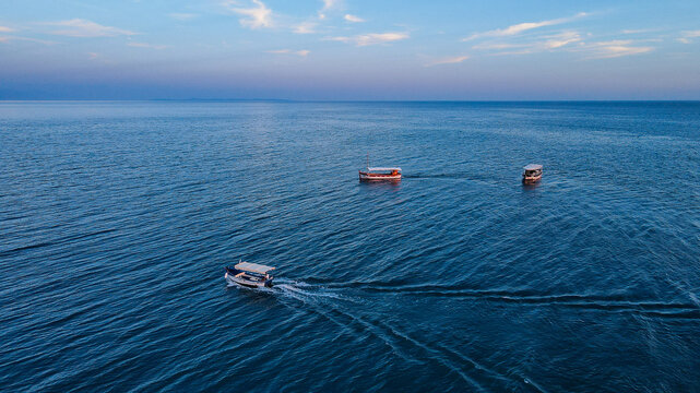 Three Boats on the Open Sea at Dusk