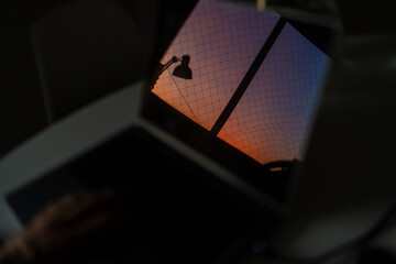 Sunset Reflection on Laptop Screen With Urban View