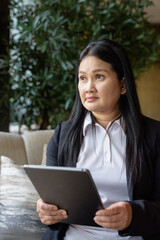 Asian businesswoman in cafe restaurant using digital tablet computer