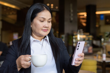 Asian businesswoman in cafe restaurant using phone