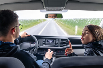 Thumbs-up passenger. Rainy car trip. Interior view.
