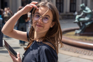 Teen girl with phone. Windy moment. Urban square portrait © puhimec