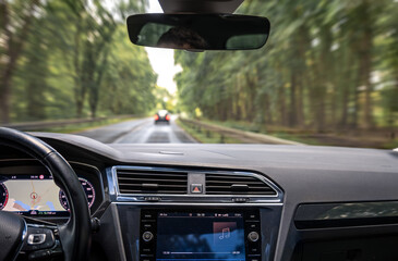Car interior in motion. Music on dashboard. Forest highway view.