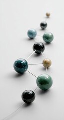 A flowing, curved line of interconnected, multicolored spheres on a white background.  Each sphere is subtly different in shade and size