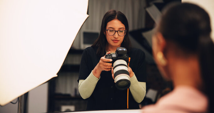 Woman, photographer and check camera in studio of photoshoot results, catalog and review selection. Female person, equipment and backstage of lens focus, editing picture and filming production on set