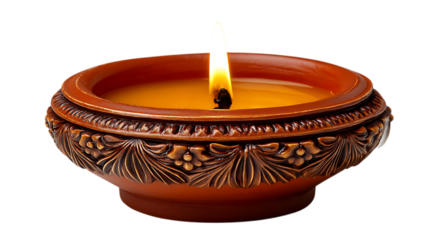 A lit decorative clay diya with intricate carvings holding a warm yellow candle flame isolated on transparent background